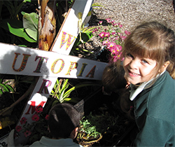 young girl checks out the school's worm garden