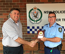 EPA staff member recieving a plaque of appreciation from police officer