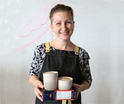 woman holding two disposable coffee cups