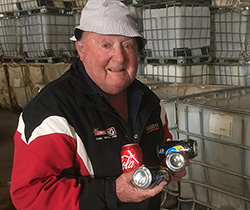 a man holding crushed aluminium cans