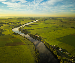 A river winds through green framland