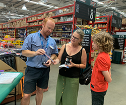 customers talking to staffer at EPA drop in information stand in hardware store