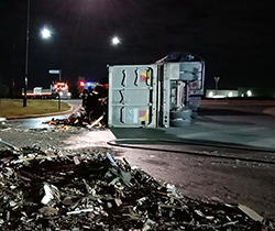 overturned truck spilling asbestos waste onto the road