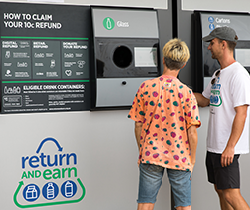 two young men return bottles to Return and Earn station for refund