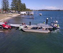 contractor in boat at jetty on Manning river during flood cleanup