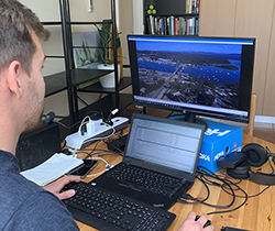 EPA officer carries out compliance check on laptop from drone images onscreen of bridge construction 