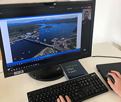 Laptop showing drone footage of bridge construction