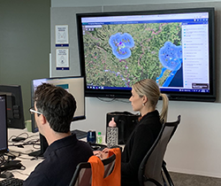 two officers read-maps-on flood-recovery