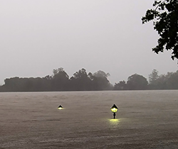 tops of glowing street lamps in deep flood water 