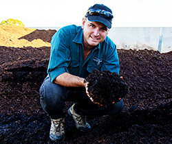 industry worker handling composted soil