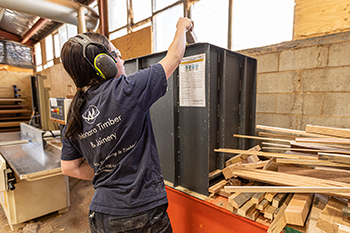 worker feeding offcut timber into the shredder