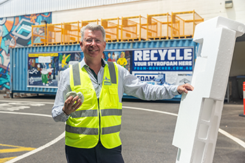 worker with large piece of polystyrene packaging